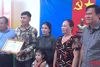 Phó Chủ tịch UBND tỉnh Cà Mau Nguyễn Minh Luân (bìa trái) trao Bằng khen của lãnh đạo tỉnh cho tài xế Phong. 