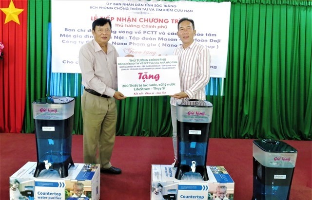 Giám đốc Sở NN-PTNT Lương Minh Quyết (bên trái) tiếp nhận thiết bị lọc, xử lý nước LifeStraw nhà tài trợ trao tặng.
