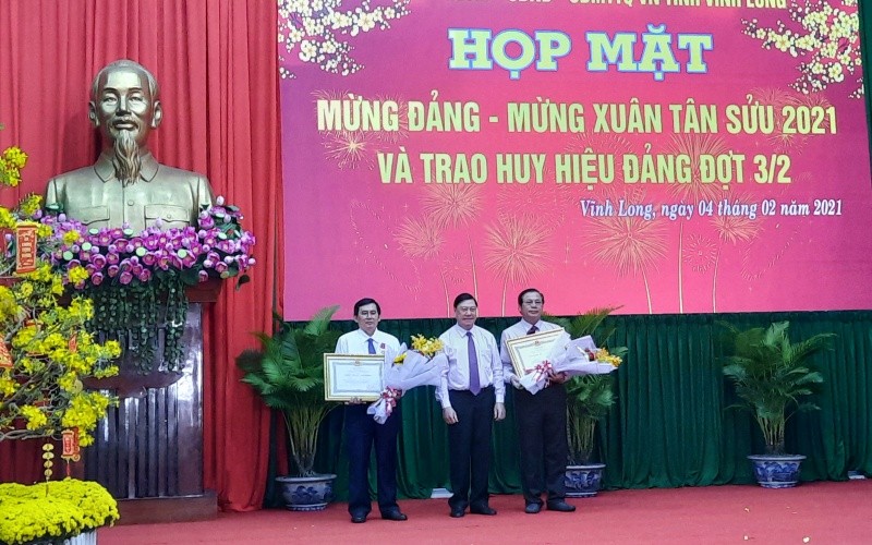 Bí thư Tỉnh ủy Vĩnh Long Trần Văn Rón thừa ủy quyền của Chủ tịch nước trao Huân chương Lao động hạng Nhì cho hai đồng chí ở Vĩnh Long.