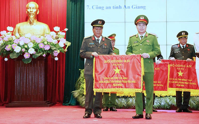 Đại tá Phạm Thành Sỹ, Giám đốc Công an tỉnh Cà Mau (trái) nhận Cờ thi đua trao tặng từ Bộ Công an.