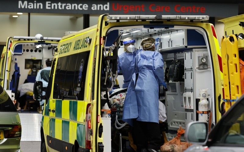 Nhân viên y tế chuyển bệnh nhân Covid-19 tới bệnh viện ở London, Anh. (Ảnh: AFP/TTXVN)