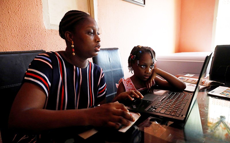 Một phụ nữ Nigeria đang cùng con học online. (Ảnh: Reuters)