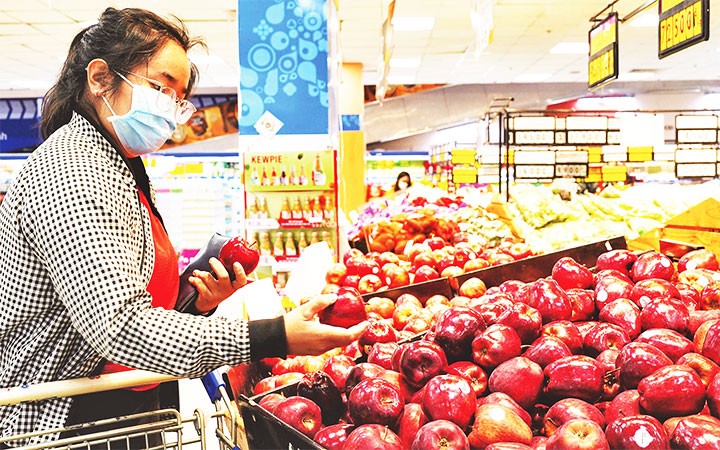 Người tiêu dùng chọn mua trái cây tại một siêu thị Co.opmart ở TP Hồ Chí Minh.