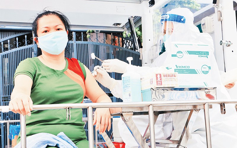 Nhân viên y tế tiêm vắc-xin cho người dân tại quận Bình Thạnh.