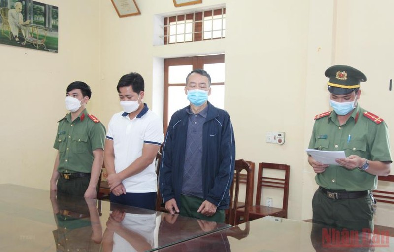Cơ quan An ninh điều tra đọc lệnh bắt tạm giam đối tượng Khánh và An. (Ảnh: TTXVN)