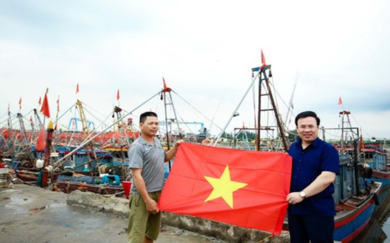 Ngư dân Nguyễn Văn Hà, trú tại đội 1, thị trấn Diêm Điền (huyện Thái Thụy, tỉnh Thái Bình) nhận cờ Tổ quốc tại cảng cá Diêm Điền.