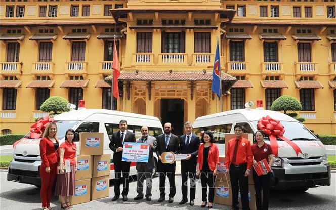 Các đại biểu trao tượng trưng xe cứu thương và vật tư y tế do Vương quốc Hồi giáo Oman tặng Hội Chữ thập đỏ Việt Nam. (Ảnh: TTXVN)