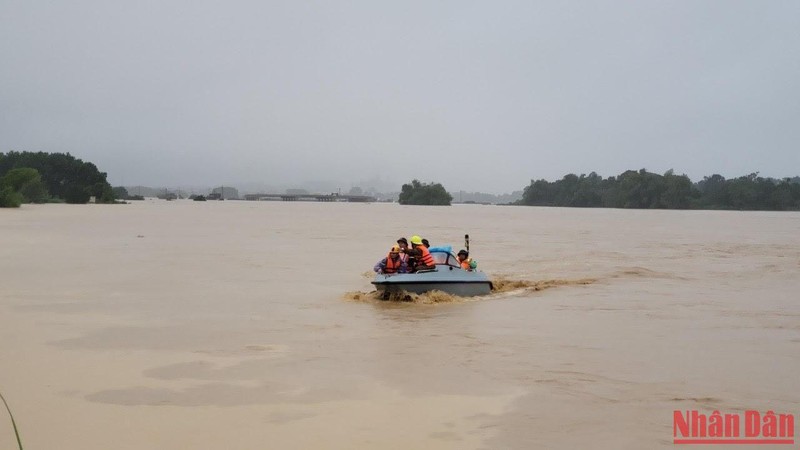 Lực lượng chức năng khẩn trương giúp người dân trong mưa lũ.