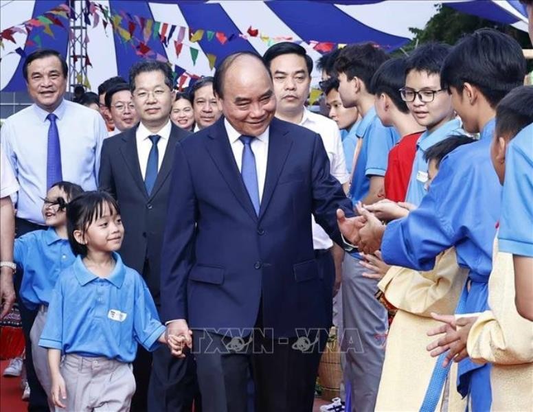 Chủ tịch nước Nguyễn Xuân Phúc với học sinh Trường Tiểu học, Trung học cơ sở và Trung học phổ thông Hy Vọng. (Ảnh TTXVN)