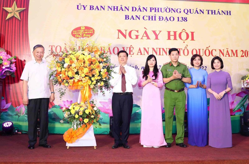 Bộ trưởng Công an Tô Lâm trao hoa cùng các phần quà tặng Đảng uỷ, UBND phường Quán Thánh, quận Ba Đình, TP Hà Nội.