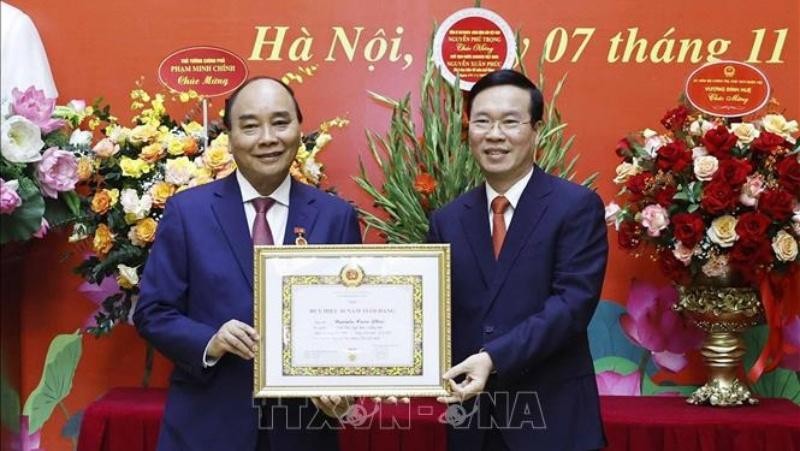 Đồng chí Võ Văn Thưởng trao tặng Huy hiệu 40 năm tuổi Đảng cho đồng chí Nguyễn Xuân Phúc. (Ảnh: Thống Nhất/TTXVN)
