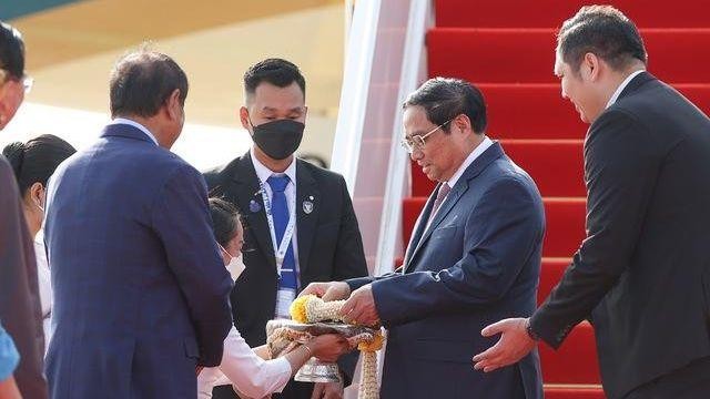 Thủ tướng Phạm Minh Chính nhận hoa chúc mừng tại sân bay quốc tế Phnom Penh. (Ảnh: VGP/Nhật Bắc)