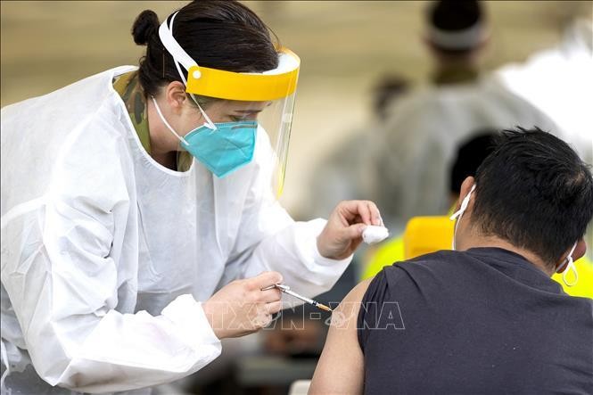 Nhân viên y tế tiêm vaccine phòng Covid-19 cho người dân tại Sydney, Australia. (Ảnh: AFP/TTXVN)