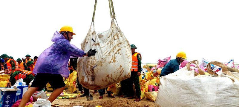 Cán bộ, nhân dân và các lực lượng vũ trang đang hỗ trợ chính quyền đắp đê gia cường bảo vệ bờ biển xã Phú Thuận sáng 11/10/2022.