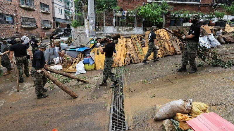 Binh sĩ dọn dẹp đường phố Seoul sau trận mưa kỷ lục ngày 9/8. (Ảnh: Yonhap)