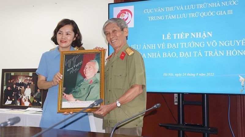 Bà Trần Việt Hoa - Giám đốc Trung tâm lưu trữ Quốc gia III tiếp nhận bức chân dung chụp Đại tướng Võ Nguyên Giáp từ Nhà báo, Đại tá Trần Hồng.