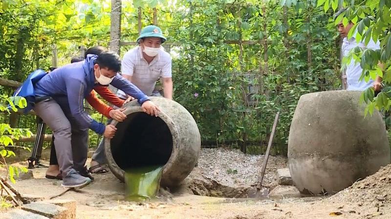 Các lực lượng chức năng trợ giúp hộ dân ở phường Hải Thanh đổ kiệt nước đọng trong các chum.